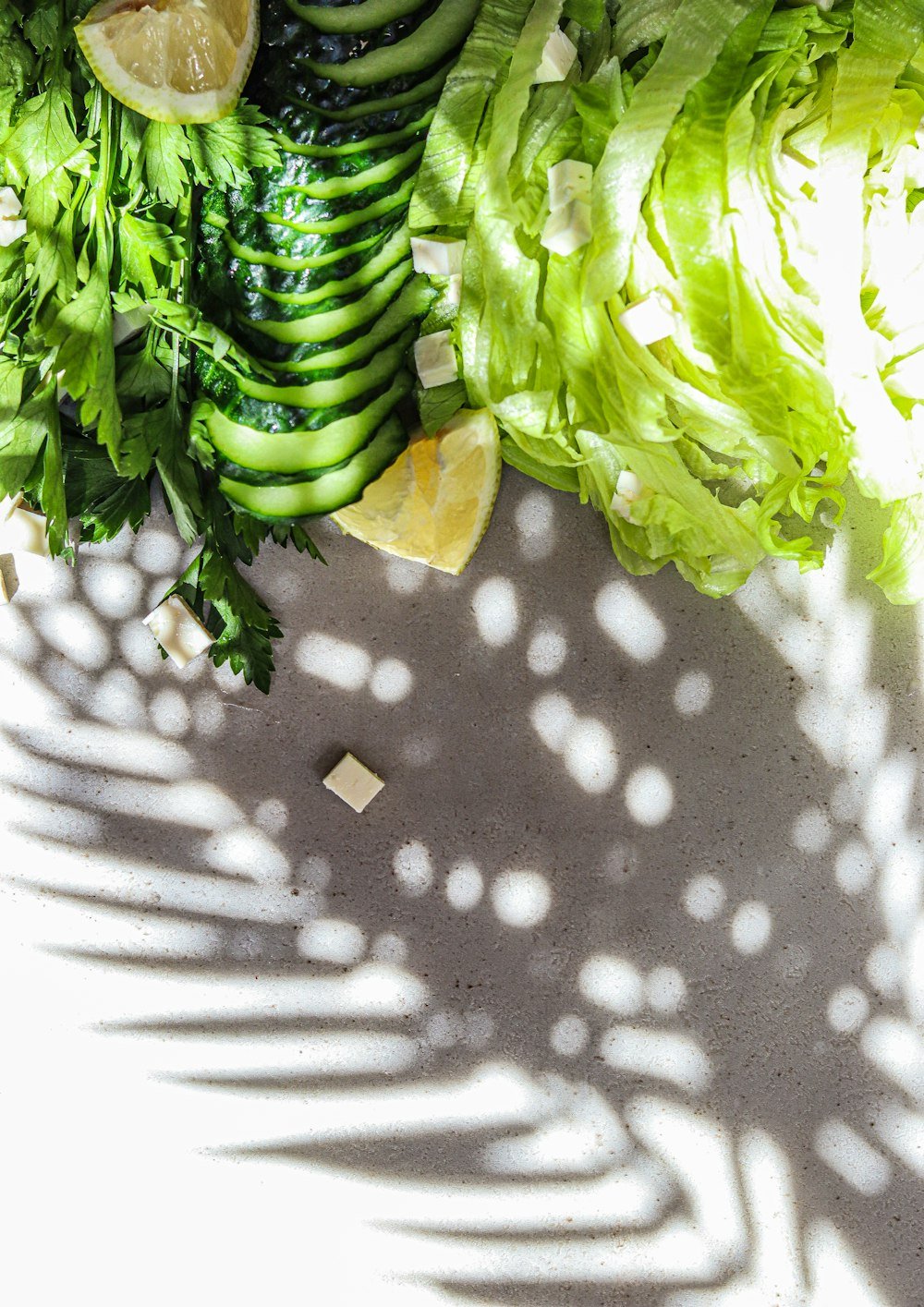 Lettuce, lemon and parsley on a white surface